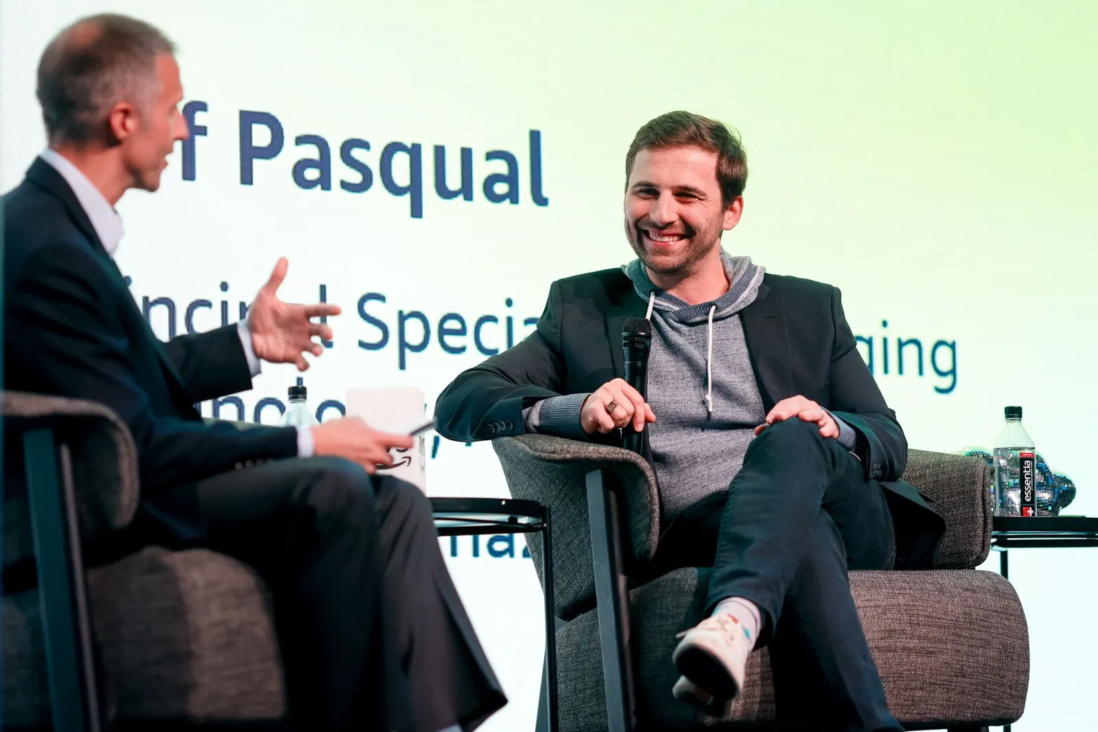 Tom Humplik, smiling and holding a microphone, in an on-stage conversation